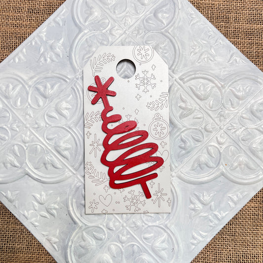 The Christmas Mini Shelf Sitters from Janet's Craft Corner feature a red, abstract spiral tree with a star on top, set against white with silver holiday doodles, displayed on a textured tile.