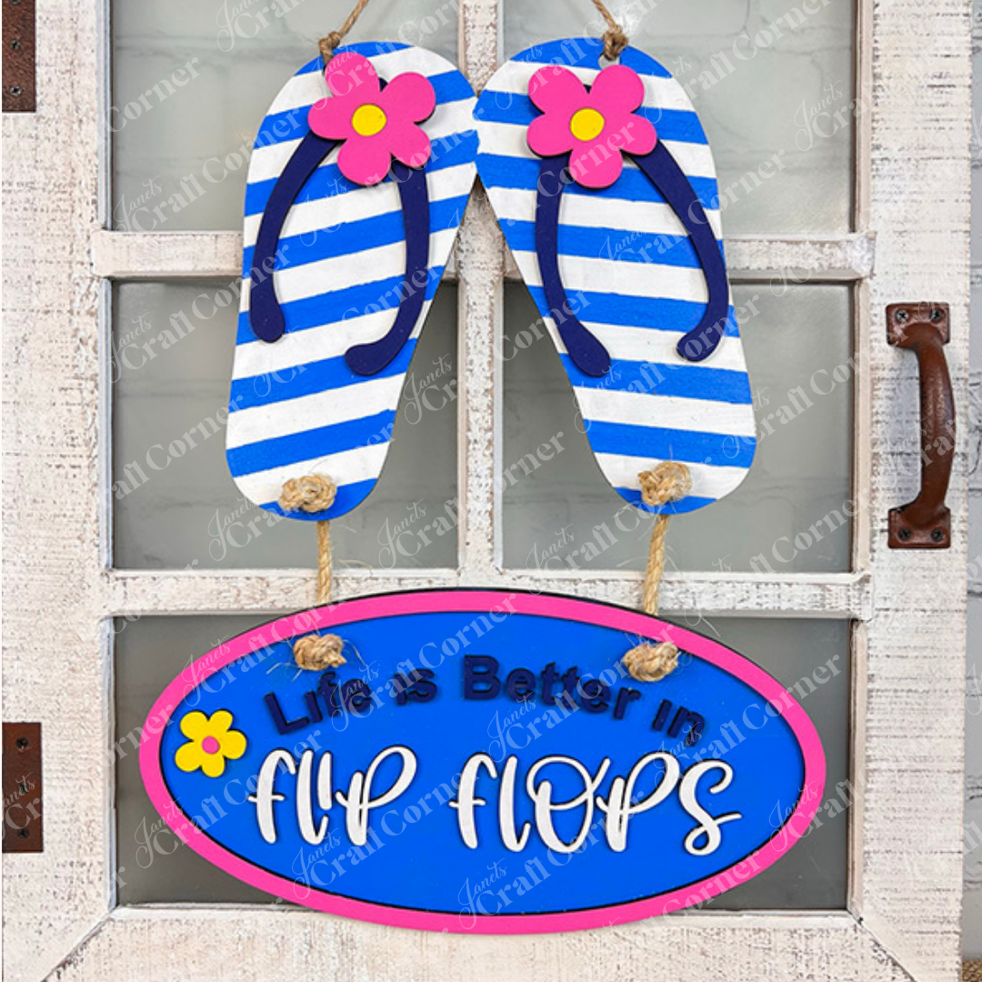 Add a coastal touch with Janet's Craft Corner Flip Flops Door Hanger DIY Kit (13.5" x 11"), featuring blue-and-white striped flip-flops, pink flowers, and an oval plaque that reads "Life is Better in Flip Flops." Ideal for beach-themed decor!.
