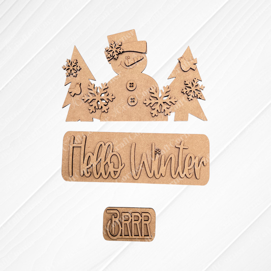 Add a festive touch to your space with Janet's Craft Corner's DIY home decor kit, the "Hello Winter Interchangeable Insert." This kit features wooden cutouts of a snowman in a hat, trees, and snowflakes. It includes pieces that read "Hello Winter" and "Brrr," making it perfect for changing up your home decor on any plain background.