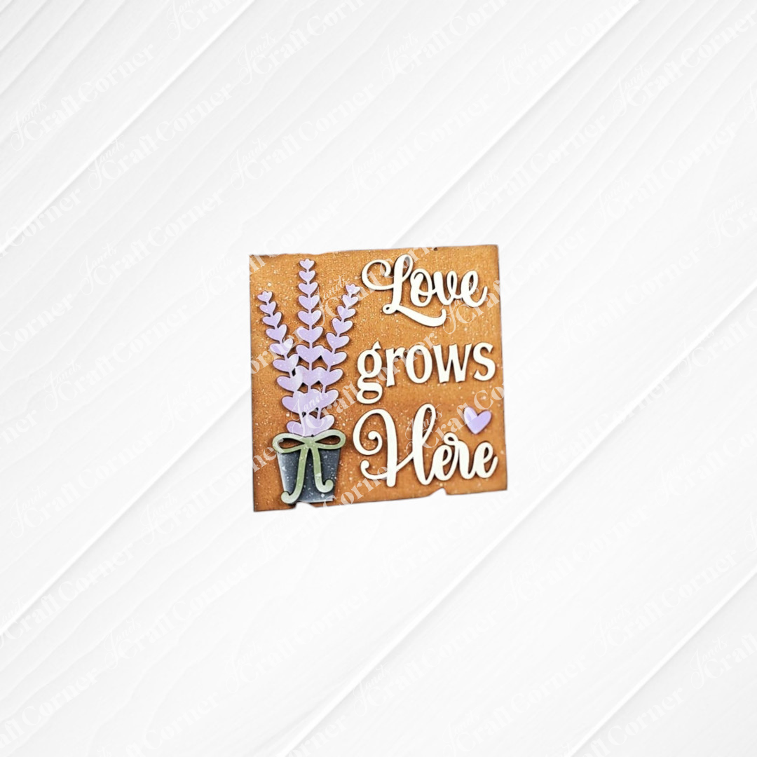 The Lavender Decor Set by Janet's Craft Corner features a farmhouse-style sign with a potted lavender plant and "Love grows Here" in white script on a brown background.