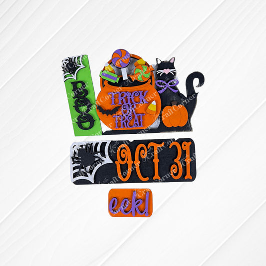 Janet's Craft Corner's Oct 31 Interchangeable Insert DIY home decor kit features Halloween-themed designs, including a hand-painted tombstone with "BOO" and a pumpkin with "TRICK OR TREAT," all artfully arranged on a textured white surface, creating a delightful display reminiscent of interchangeable home decor sets.