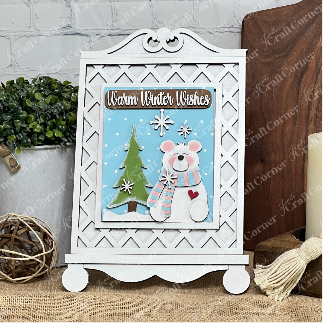Display the "Warm Winter Wishes" sign—a snowy bear scene—using Janet's Craft Corner Cottage Frame for Switchable Farmhouse Signs, a DIY seasonal home decor craft kit that lets you change wall art easily. Set of 1.