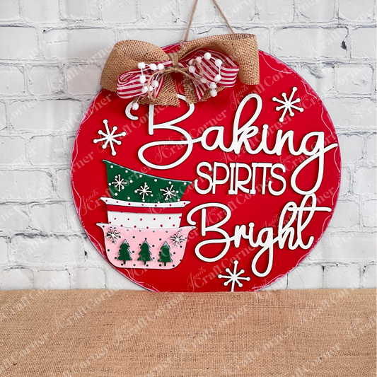 Add a festive touch to your space with the Heartland Baking Spirits Bright Bowls Door/Wall Hanger—a painted red, round sign featuring stacked holiday bowls, snowflakes, and the cheerful phrase “Baking Spirits Bright,” finished with a decorative bow. Perfect as Christmas door decor or charming holiday baking wall art, this piece brightens up any white brick wall.