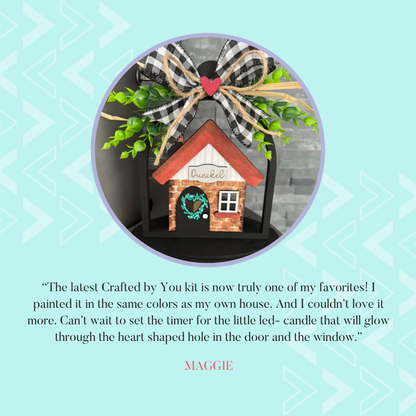 A delightful house-shaped shelf sitter, featuring a heart door and window in red and brown, topped with a bow. This Home Cloche Votive Holder comes from Janet's Craft Corner with Maggie's note on enjoying the DIY home decor craft kit.