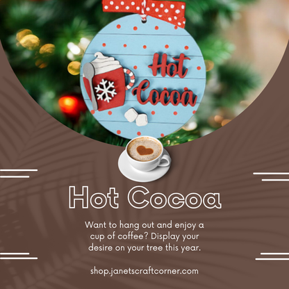 Enhance your home décor with our "Hot Cocoa Round Ornament," featuring a blue ornament marked with "Hot Cocoa," a snowflake, and cocoa topped with heart-shaped foam. Available at Janet's Craft Corner: shop.janetscraftcorner.com.
