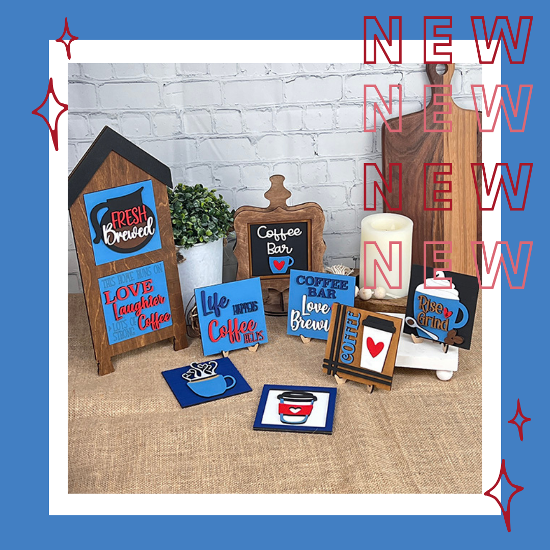 A burlap-covered table displays Janet's Craft Corner Coffee Squares—colorful, coffee-themed wooden signs and coasters—great for small spaces or DIY decor. Candles, a plant, and repeated "NEW" text in red appear in the background.