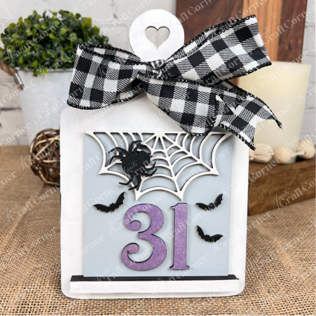 The Oct 31 Squares by Janet's Craft Corner is a Halloween sign featuring a black-and-white checkered bow, spider web, two bats, and purple "31." Ideal as festive tiered tray decor for your home.