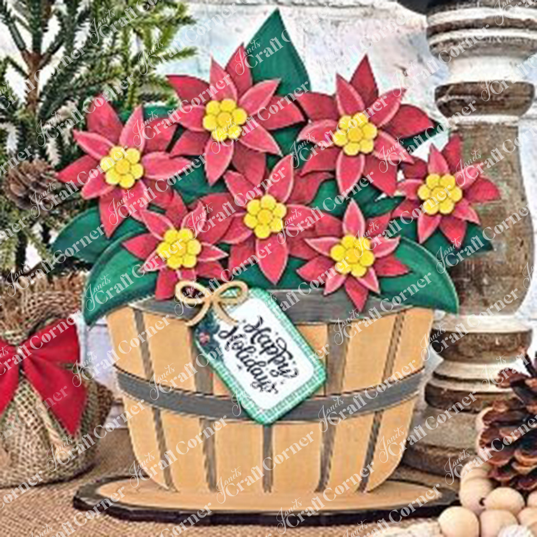 Janet's Craft Corner presents the "Basket of Poinsettia," featuring a wooden basket filled with vibrant red poinsettia blooms, lush green leaves, and cheerful yellow centers, elegantly topped with a decorative "Happy Holidays" tag. This delightful arrangement exudes the charm of a DIY craft kit and is beautifully set against a rustic backdrop.