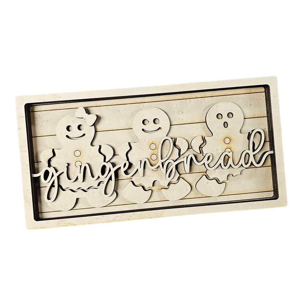 The delightful Gingerbread Chunky Shelf Sitter DIY Home Decor Kit by Janet's Craft Corner features a wooden piece with three gingerbread figures, smooth edges, and the word "gingerbread" elegantly displayed. Its rustic, light wood finish makes it a charming addition to any home décor.