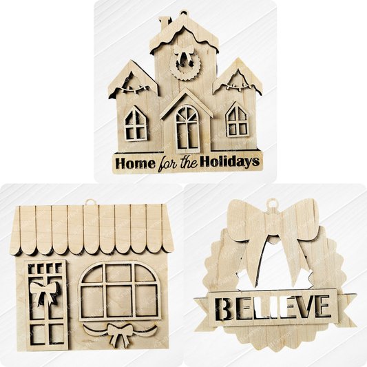 Three wooden holiday ornaments from Janet's Craft Corner include a house inscribed with "Home for the Holidays," a building featuring a window adorned with a bow, and a wreath with "BELIEVE." This hand-painted Holiday Village Ornament Set - Early Access is perfect for adding warmth and charm to any festive display.