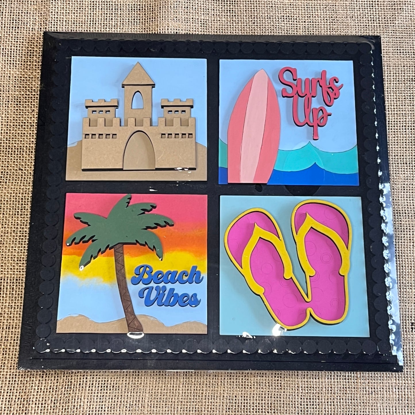 The Heartland Bead Trim Swappable Squares Frame with Inserts - Painted features four vibrant beach-themed images—sandcastle, surfboard (“Surf’s Up”), palm tree (“Beach Vibes”), and pink flip-flops—ideal for DIY crafts and décor.
