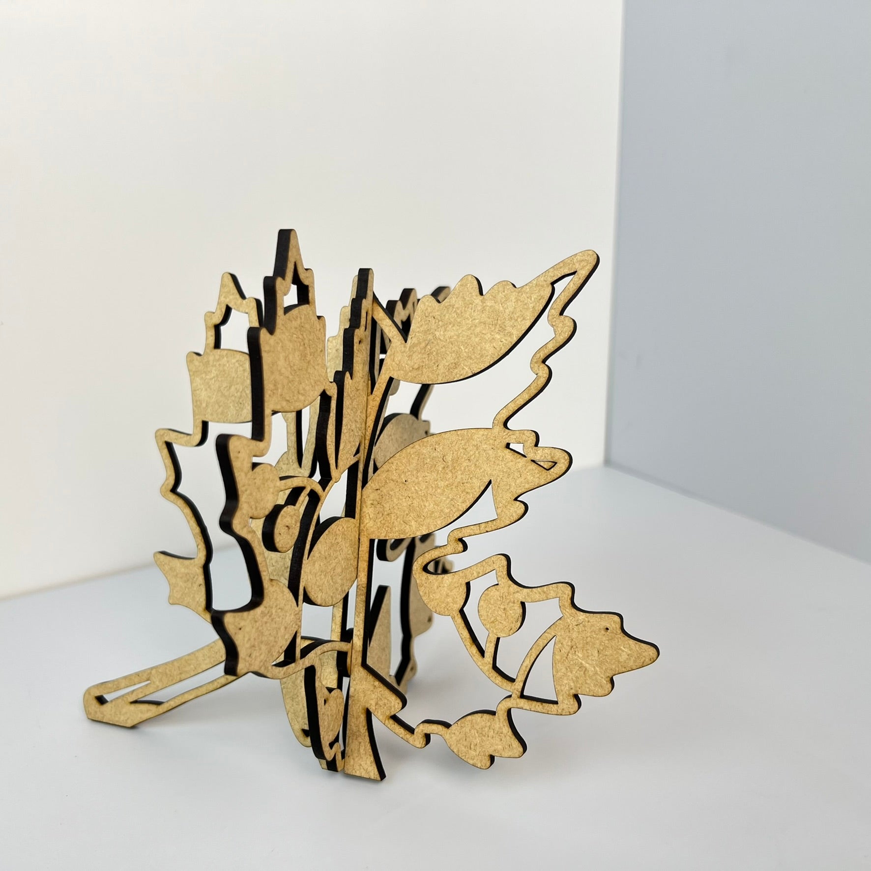 A set of six 3-D shelf sitters from Janet's Craft Corner rests on a white surface, showcasing laser-cut wooden artistry with abstract shapes and leaf-like designs. Ideal for rustic décor, the Fall Leaves set is meticulously crafted with visible layers and precision-cut edges.