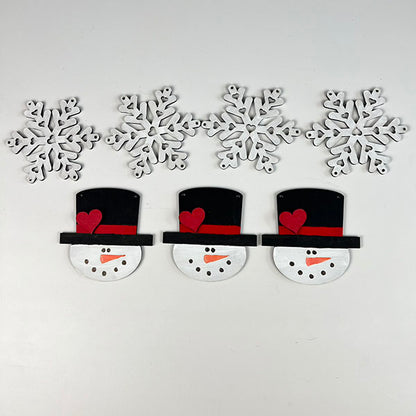 Five wooden snowflake decorations in white are positioned at the top. Just below, the Snowman and Snowflake Banner from Janet's Craft Corner features charming snowmen with black top hats, red bands, and red hearts arranged on a white background—ideal for infusing your home with farmhouse winter decor charm.