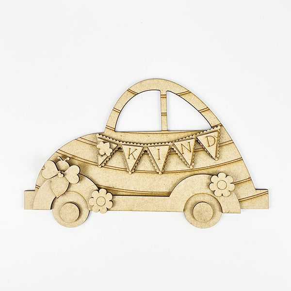 The Bee Volkswagen Shelf Sitter by Janet's Craft Corner is a DIY decor piece with floral designs and "KIND" flags. Resembling a classic car, it's perfect for a farmhouse touch with intricately lined wheels and charming style.