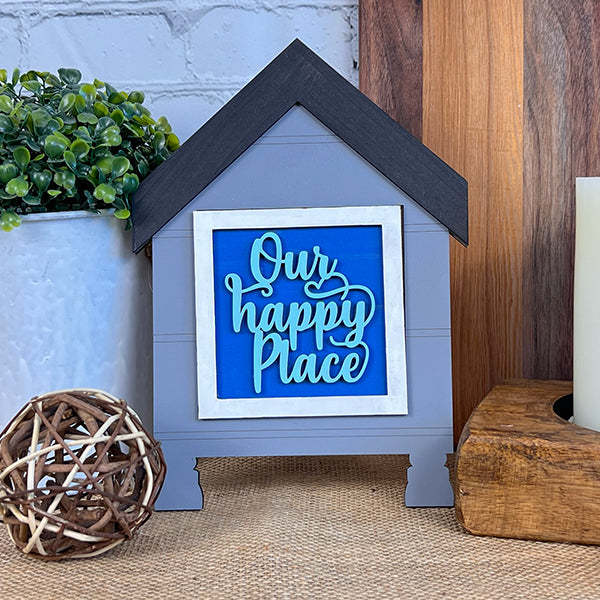 Add a farmhouse touch with Janet's Craft Corner House Swappable Squares Holders Shelf Leaner DIY Craft Kit—a small, gray, house-shaped tabletop sign with a blue center that's perfect near plants or candles. Set includes 1 piece.
