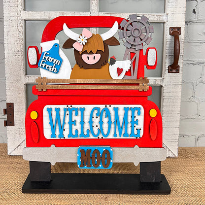 This delightful sign from Janet's Craft Corner, the Farm Welcome Interchangeable Insert, features a charming red truck decorated with a cow, chicken, and windmill set against a white brick wall. The truck bed is labeled "Farm Fresh," and its tailgate joyfully displays "WELCOME" and "MOO." Ideal for DIY enthusiasts, this home decor kit offers an appealing hand-painted style simplicity!