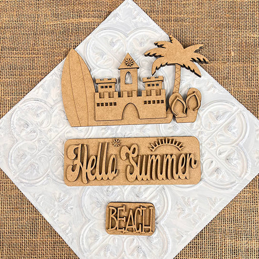 The Summer Beach Interchangeable Insert, a DIY home decor kit by Janet's Craft Corner, features wooden beach-themed cutouts on a textured surface. This versatile decor set includes a surfboard, sandcastle, palm tree, flip-flops, and signs engraved with "Hello Summer" and "Beach." The burlap background with a white tile pattern adds charm and adaptability to any space.