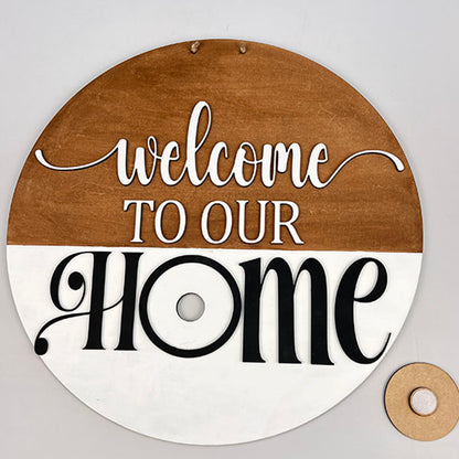 The Welcome to Our Home Door Hanger Interchangeable Set from Janet's Craft Corner makes for a delightful home décor piece with its distinctive two-tone round wooden design. The upper section features a brown background with "welcome TO OUR" in elegant white, and the lower section displays "HOME" in striking black against a white backdrop. A small ring is included, allowing this versatile décor item to adapt seamlessly to any space.