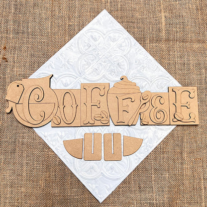 The Coffee Word Block DIY kit by Janet's Craft Corner spells "COFFEE" with a cup and jar motif on white textured tile and burlap, plus extra wooden shapes—perfect seasonal home decor for coffee lovers. Set of 1.