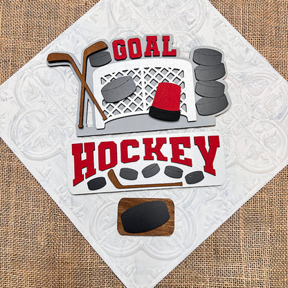 The Hockey Interchangeable Insert - Painted, from Janet's Craft Corner, showcases a decorative hockey-themed design with elements like a goal net, hockey sticks, pucks, and the words "Goal" and "Hockey" in red on a textured white and burlap background. This piece is an ideal addition to your home decor collection.