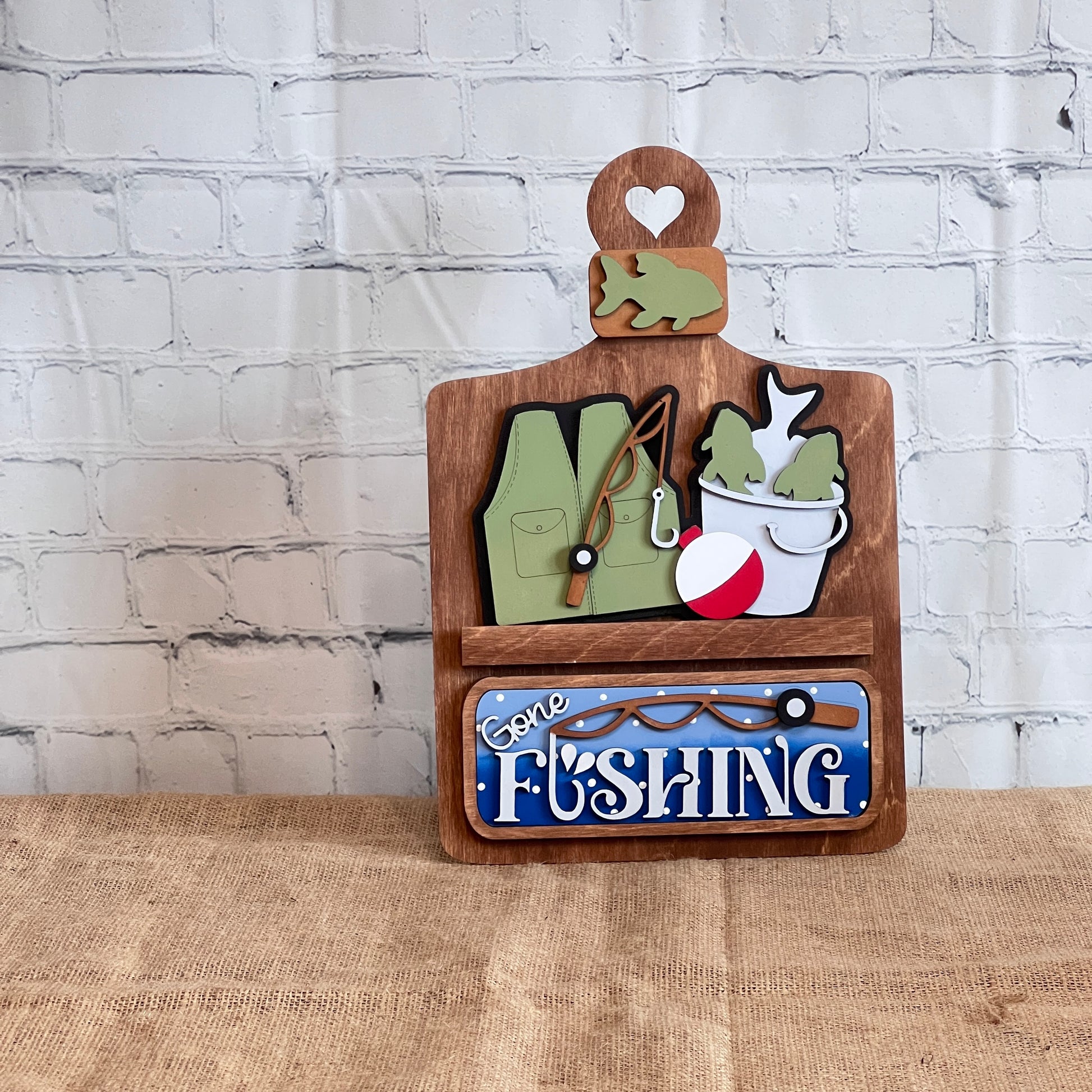 Janet's Craft Corner’s Gone Fishing Interchangeable Insert DIY craft kit (set of 3) features fishing-themed wood cut-outs and a blue "Gone Fishing" plaque—perfect for seasonal home decor crafting on any tabletop or shelf.