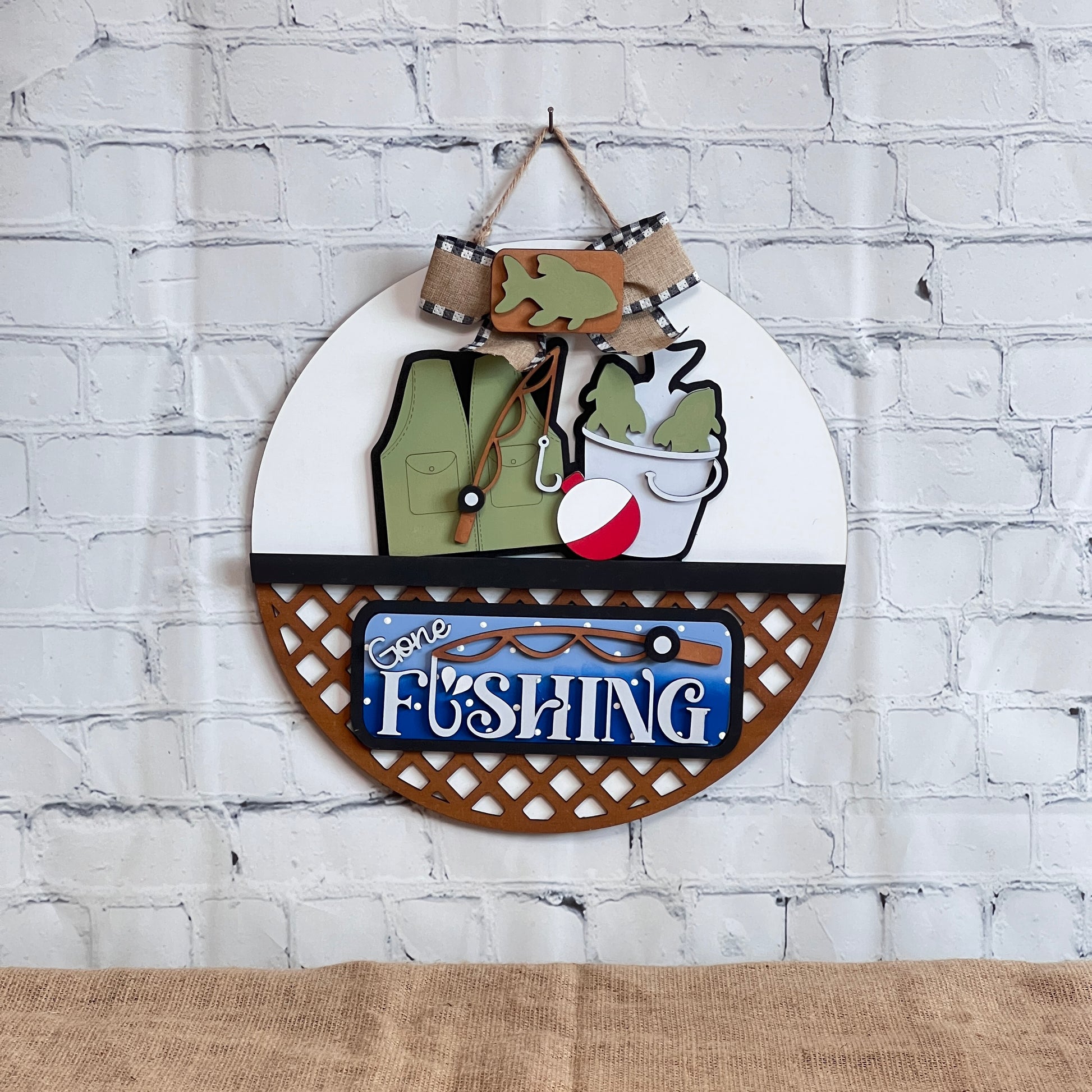 The Gone Fishing Interchangeable Insert by Janet’s Craft Corner is a DIY seasonal home decor craft kit (set of 3) featuring a fishing vest, fish, bucket, bobber, and "Gone Fishing" sign—perfect for your next crafting adventure.