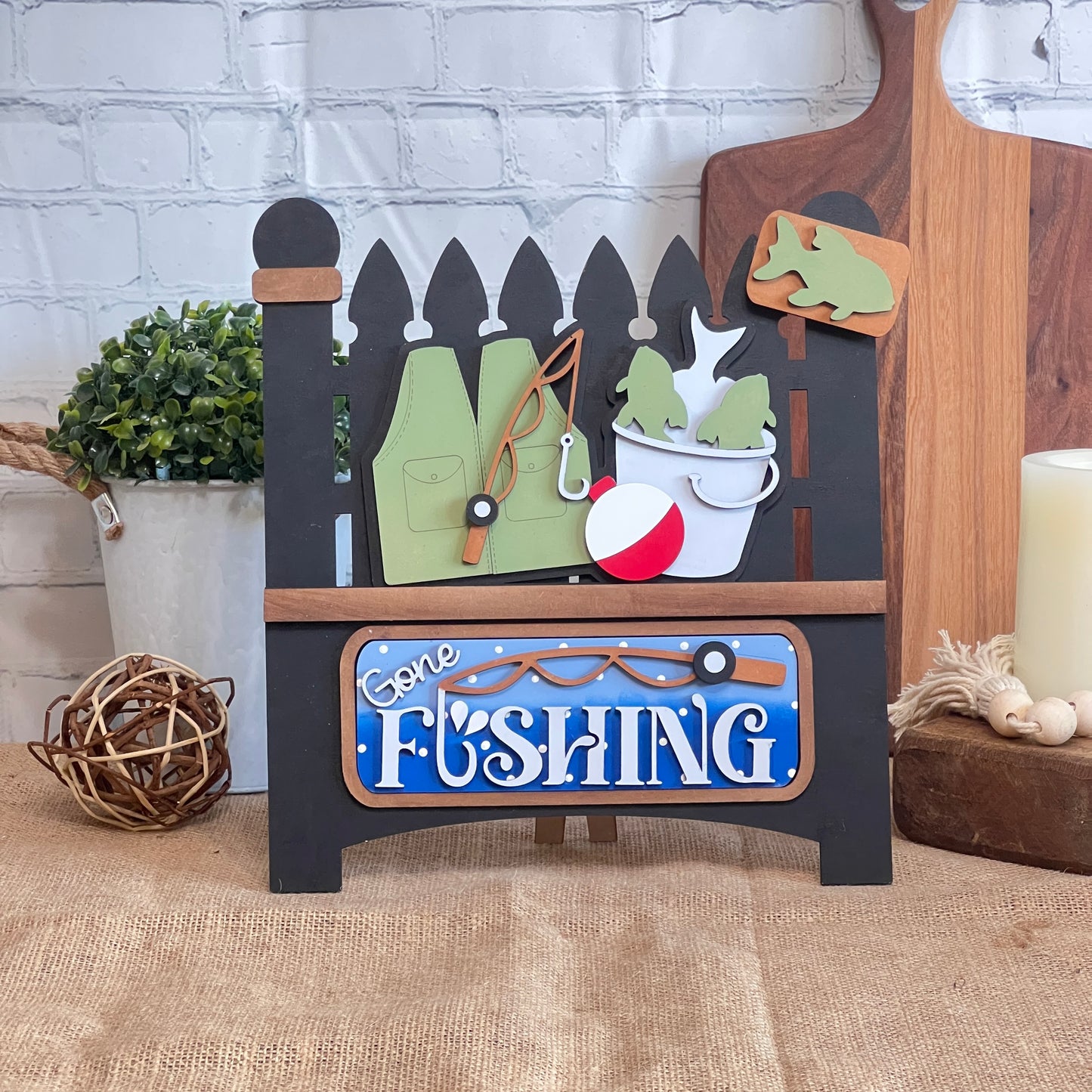 Janet's Craft Corner Gone Fishing Interchangeable Insert is a DIY seasonal home decor craft kit featuring 3 fishing-themed pieces, perfect for adding rustic charm to your space.