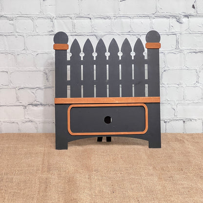 The Garden Fence Interchangeable Base - Painted by Janet's Craft Corner is a decorative dark gray wooden box with orange-brown trim, ideal for DIY home decor or as part of a craft kit for interchangeable inserts.