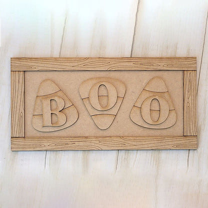 Janet's Craft Corner Boo Candy Corn Shelf Leaner DIY kit features three candy corn shapes with cut-out "B", "O", and "O" letters, a wood grain border, and is perfect for decorating your home this Halloween. Set of 1.