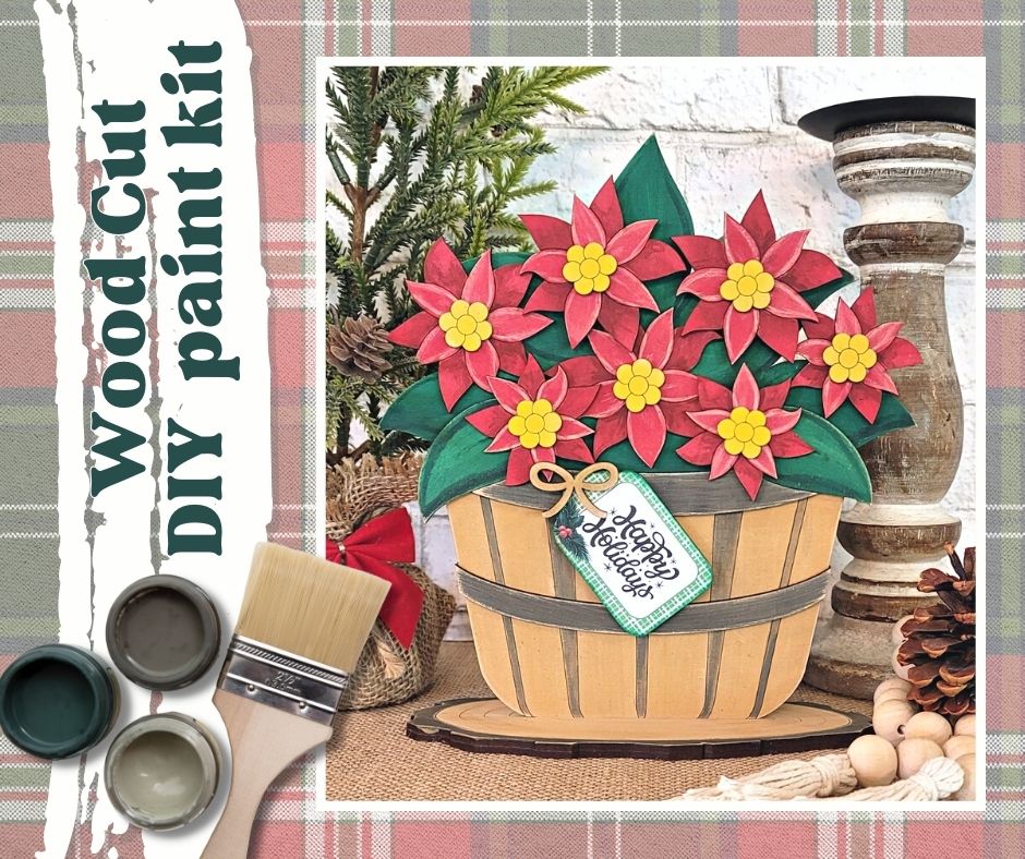 The Basket of Poinsettia from Janet's Craft Corner includes a gorgeous arrangement of red poinsettias with yellow centers in a wooden basket. It comes complete with paint, a brush, and a "Happy Holidays" tag, all set against a festive red and green plaid pattern background.