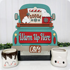 The Hot Cocoa Interchangeable Insert DIY home decor kit by Janet's Craft Corner adds charm to your space with its truck-themed sign featuring the phrases "Warm Up Here" and "Cozy," surrounded by illustrations of hot cocoa, marshmallows, and snowflakes. It also includes two adorable ceramic mugs with smiling faces, making it a perfect project for personalizing your home.