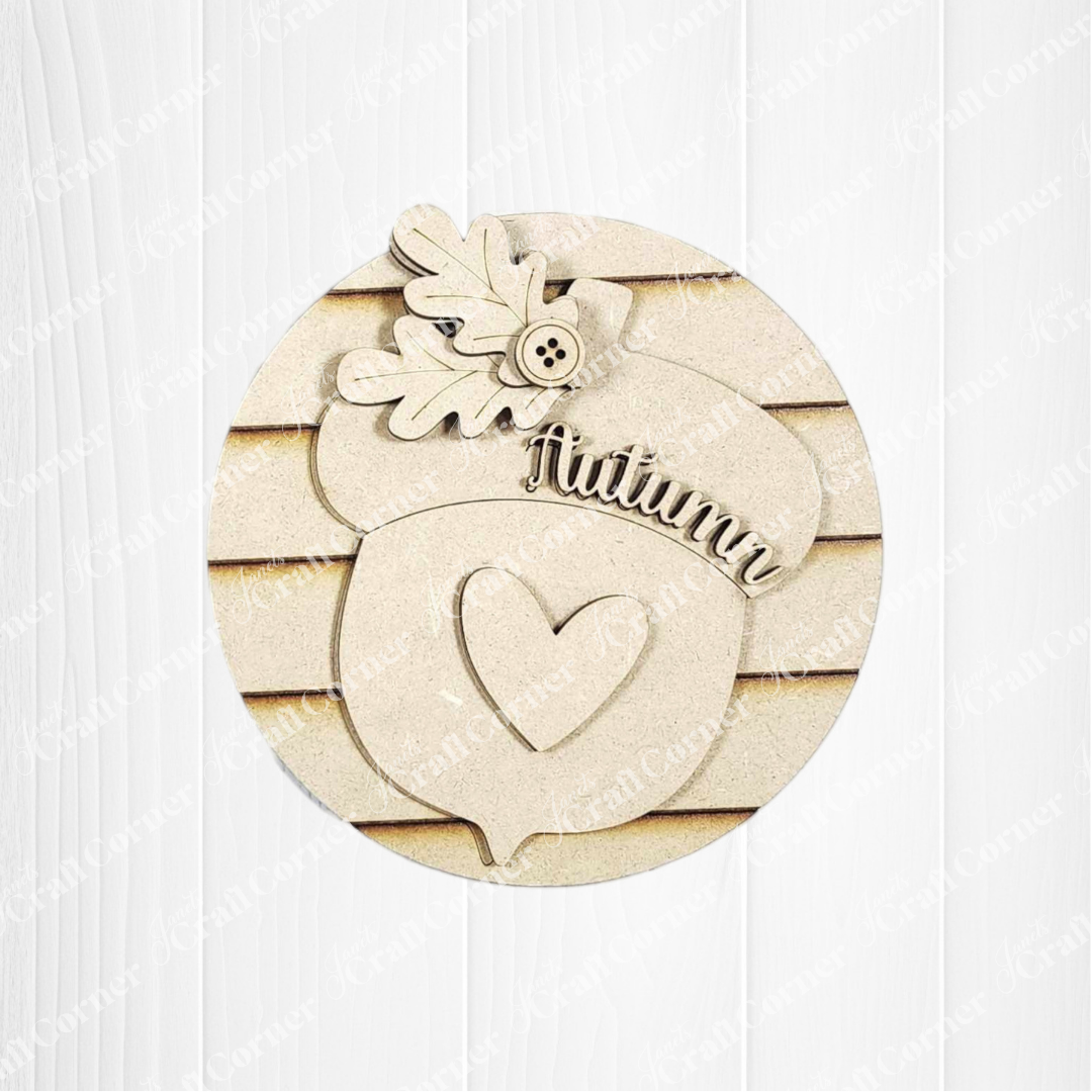 Add autumn charm to your home with Janet's Craft Corner Fall Harvest Mini Shelf Sitters DIY kit—a wooden acorn cutout with heart, "Autumn," oak leaves, and button. Perfect seasonal decor for shelves! Set of 1 included.