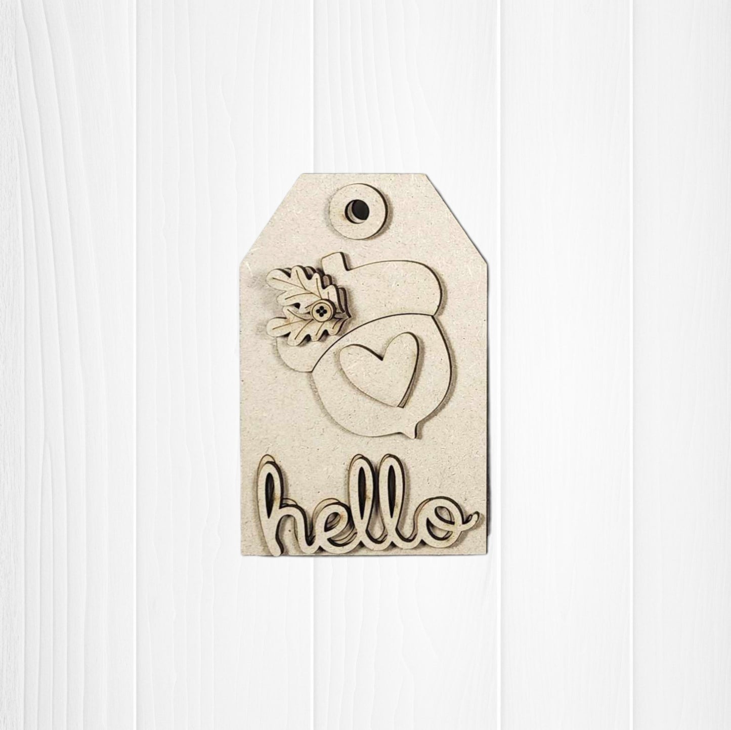 The Fall Harvest Mini Shelf Sitters by Janet's Craft Corner is a DIY home decor craft kit with a cutout heart, flower, and "hello"—perfect for autumn decorating. Display on a white wood background for cozy seasonal charm. Set of 1 included.