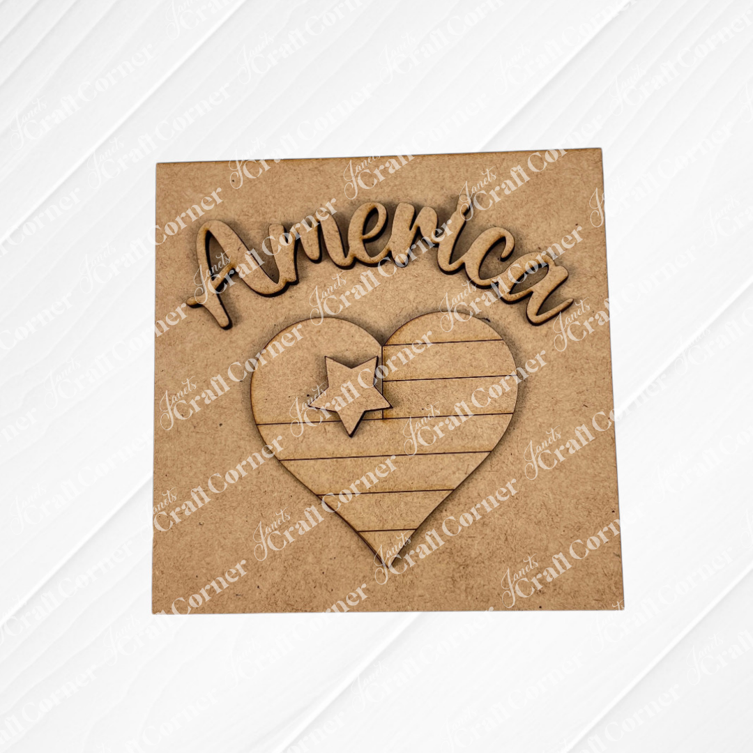 Janet's Craft Corner Patriotic Squares DIY seasonal home decor kit features a laser-cut wooden "America" sign above a heart with a star and stripes on a square background—ideal for Independence Day décor or crafting.
