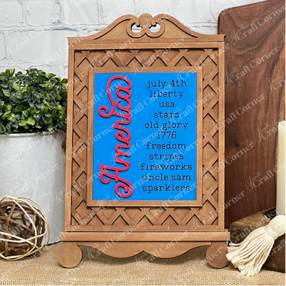 The Patriotic Farmhouse Signs DIY kit by Janet's Craft Corner includes a decorative wooden frame with a blue "America" sign and patriotic phrases—ideal for rustic spring decor or styling tiered trays and tables. Set of 1.