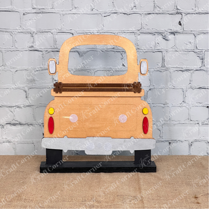 The Antique Truck Interchangeable Base  Standing DIY home decor kit by Janet's Craft Corner features wooden cutout pieces which have been painted copper, displayed on a white brick background.