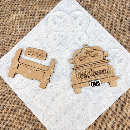 Create a delightful DIY kit with wooden cutouts from Janet's Craft Corner's "Antique Truck Ornament" collection. The truck features "Hot Cocoa" accompanied by mugs on the bed ideal for personalizing your Christmas décor. The pieces maintain their natural wood finish, highlighting their vintage charm against a textured background.