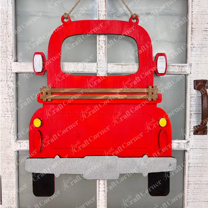 The Antique Truck Interchangeable Base  Hanging DIY home decor kit by Janet's Craft Corner features wooden cutout pieces which have been painted red, displayed on a white brick background.