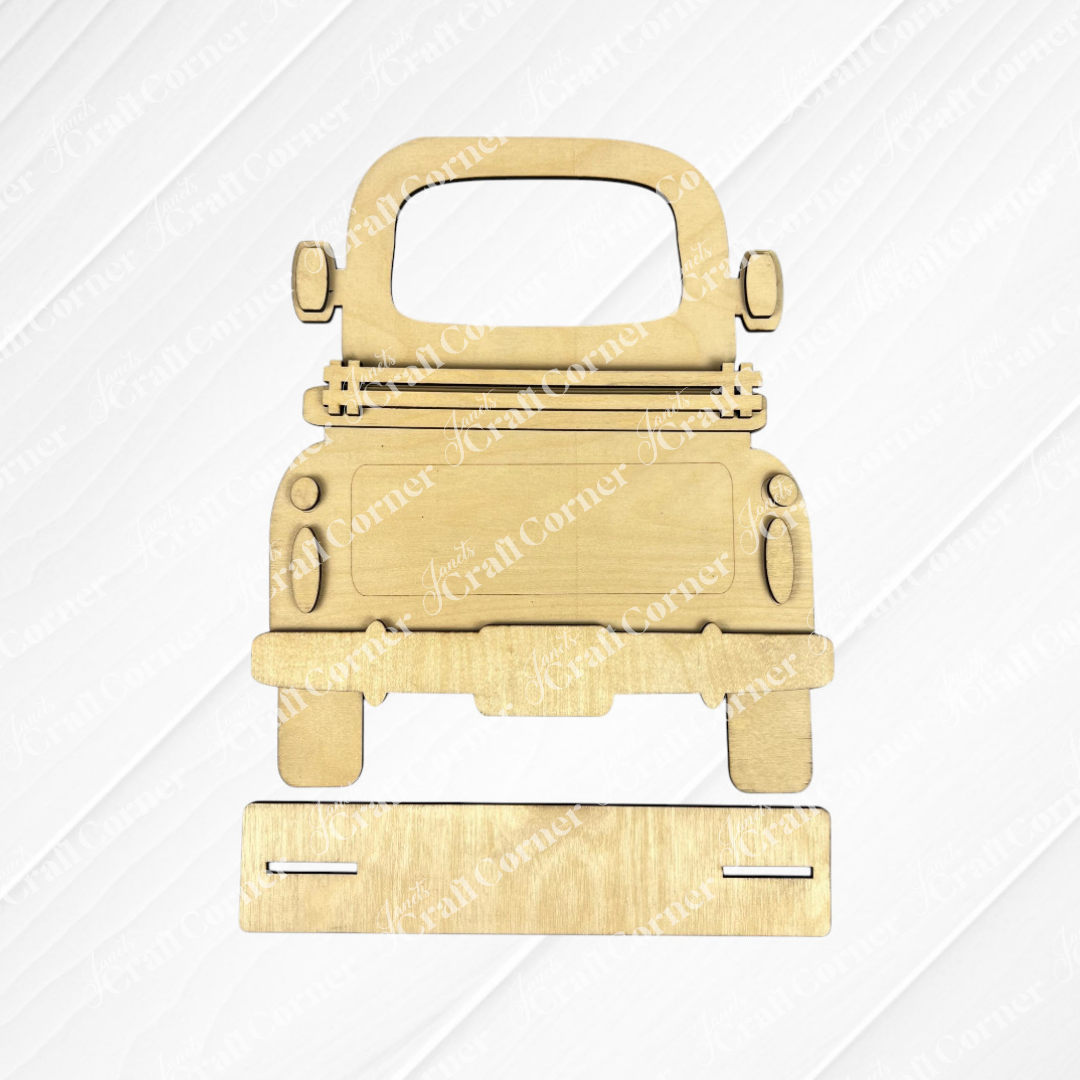 The Antique Truck Base with Interchangeable Insert DIY home decor kit by Janet's Craft Corner features wooden cutout pieces and a hand-painted assembly setup, displayed on a gray background.