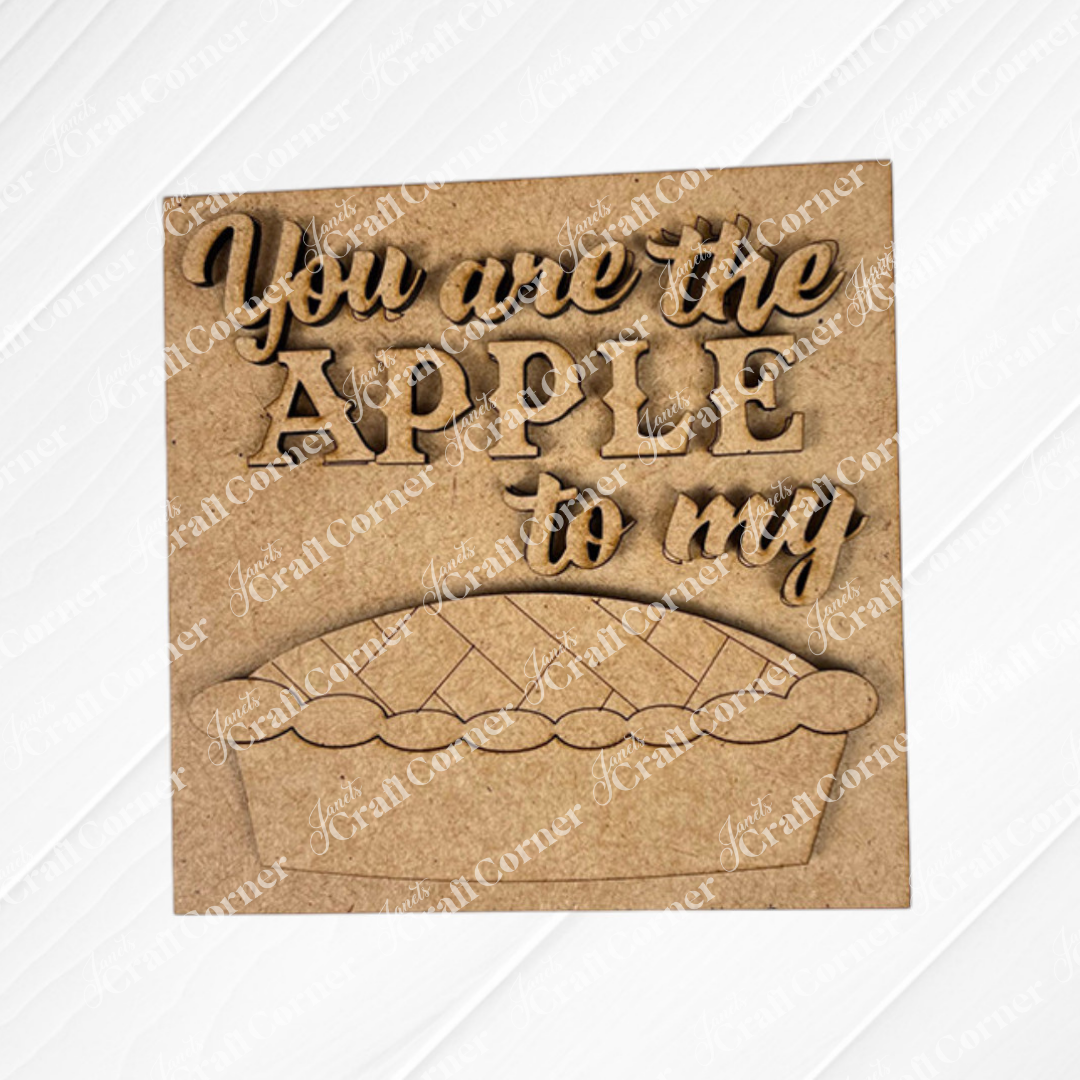 Janet's Craft Corner apple pie square features a wooden sign with raised "You are the apple to my" lettering and a pie cut-out—perfect for DIY seasonal home decor, displayed on a painted white textured surface.