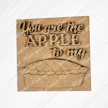 Janet's Craft Corner apple pie square features a wooden sign with raised "You are the apple to my" lettering and a pie cut-out—perfect for DIY seasonal home decor, displayed on a painted white textured surface.