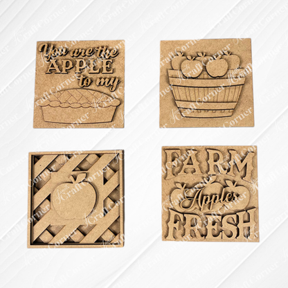 Janet's Craft Corner Apple Swappable Squares DIY kit includes four wooden signs with apple cut-outs: "You are the apple to my pie," a basket, a striped apple, and "Farm Fresh Apples." Perfect for seasonal home decor.