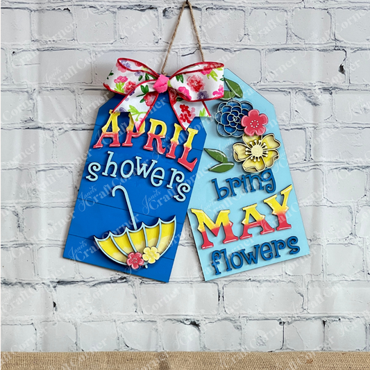 Janet's Craft Corner April Showers Door Tags feature two colorful farmhouse signs—one with an umbrella and “April showers,” the other with flowers and “bring May flowers”—finished with floral bows. Perfect spring DIY decor.