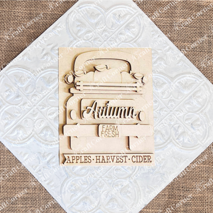 Janet's Craft Corner presents the Autumn Truck Interchangeable Sign, a DIY home decor craft kit featuring a hand-painted wooden plaque. The design includes an intricately carved "Autumn" and a charming truck with "Farm Fresh" on its tailgate, accompanied by the text: "Apples - Harvest - Cider." Ideal for enhancing your seasonal decor.