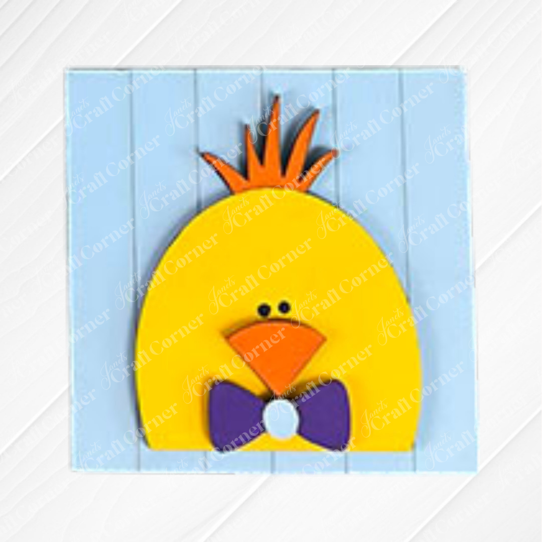 A cartoon-style yellow chick with an orange beak, spiky crest, and purple bow tie stands on a light blue wooden background—perfect for adding to your Hello Easter Squares kit from Janet's Craft Corner.