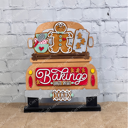 The Baking Spirits Bright Interchangeable Insert - DIY Craft Kit from Janet's Craft Corner features a wooden decoration with a car in a gingerbread theme. It is embellished with a gingerbread man, rolling pin, and cookie tray, and showcases the phrases "Baking Spirits Bright" and "Cookies" against an attractive brick wall on burlap.