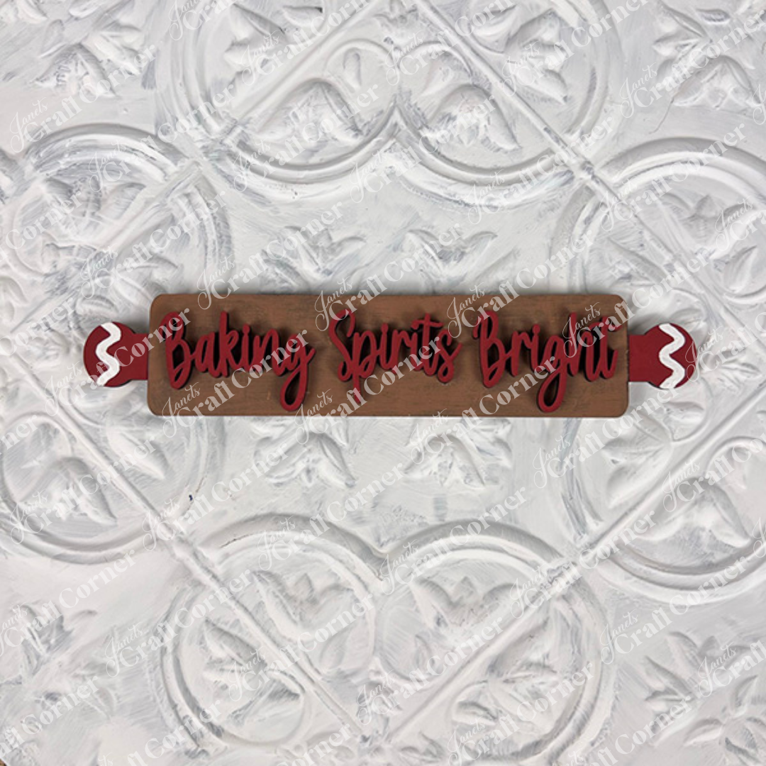 The Vintage Santa Cookies Decor Set by Janet's Craft Corner is a DIY craft kit with a wooden rolling pin featuring red handles and "Baking Spirits Bright" in red script, perfect for holiday tiered trays or festive home decor.