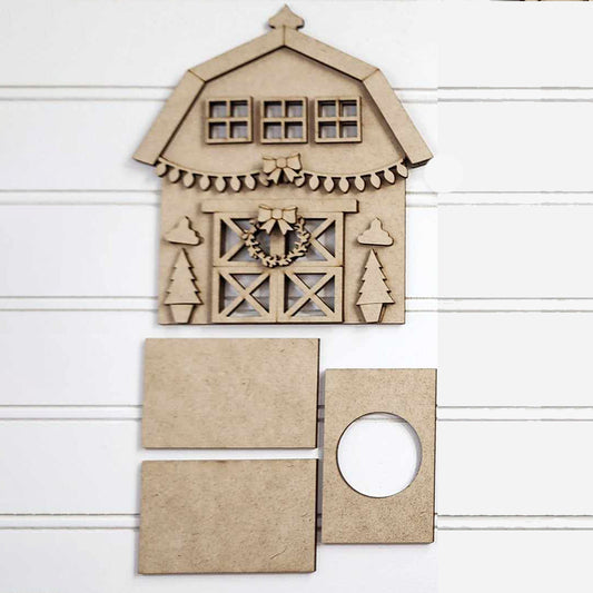 Janet's Craft Corner presents the Barn Farmhouse Votive Holder DIY Decor Kit, featuring charming wooden craft pieces on a white background. The standout piece is the Barn Farmhouse Votive Holder, adorned with windows and a wreath. Among the other rectangular pieces is one with a circular cutout, perfect for your next hand-painted project.