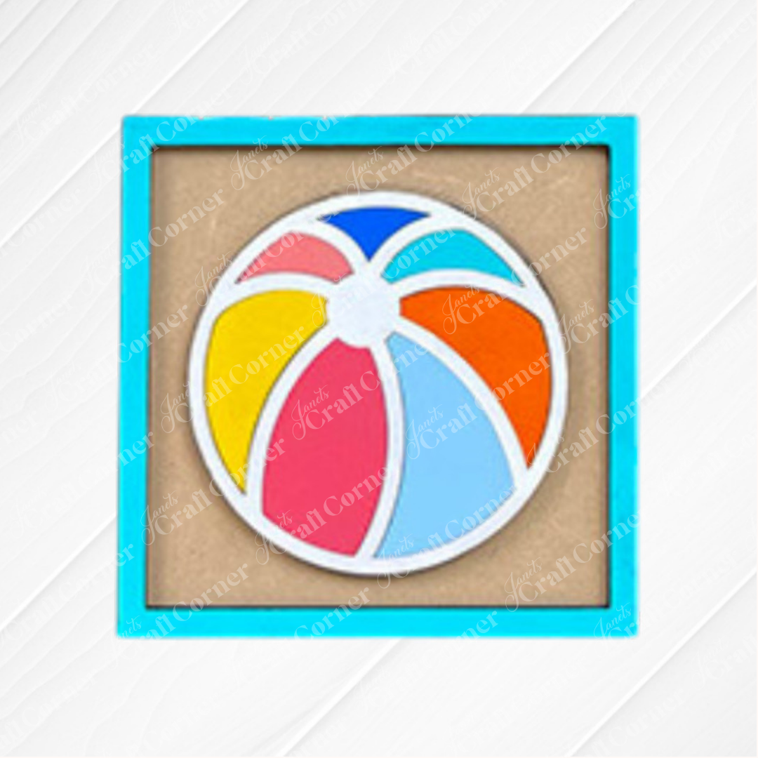 Janet's Craft Corner’s Summer Beach Squares DIY craft kit features a beach ball cookie in blue, red, yellow, orange, and light blue inside a square blue frame—ideal for coffee bar decor or pairing with beach-themed tray signs.