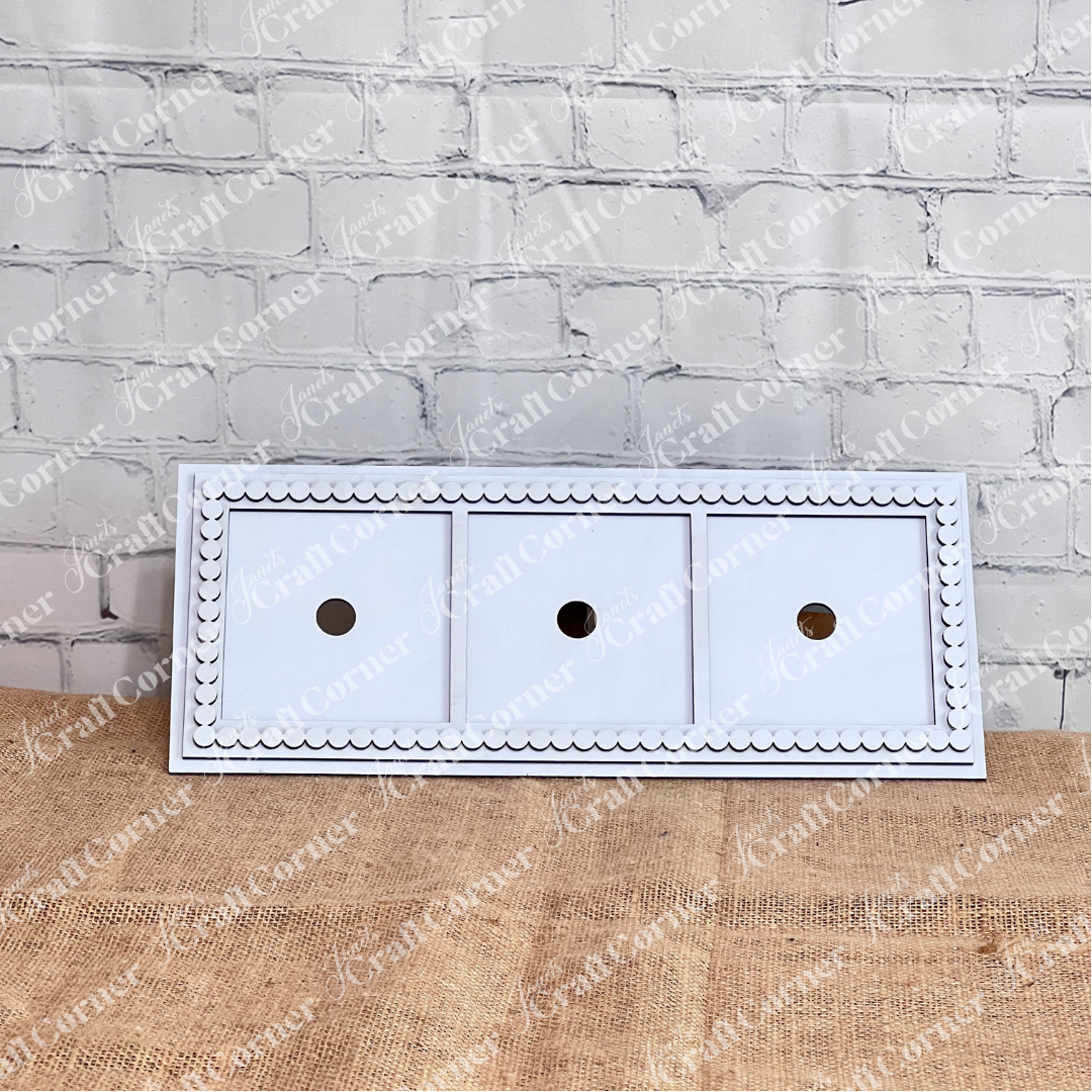 The Heartland Bead Trim Swappable Squares Frame is a rectangular white wood panel with three square drawers, each with a round hole handle and decorative bead trim, perfect for displaying swappable signs against any background.
